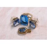 A marked 9ct. yellow metal dress ring, set with large pale blue stone - sold with a similarly set