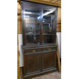 A 4' early 20th Century stained walnut two part book cabinet with moulded cornice and flanking