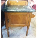 An early 20th Century stained mixed wood washstand with faux marble top and panelled door under, set