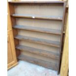 A 3' 6" mid 20th Century stained pine five shelf open bookcase with later hardboard backing