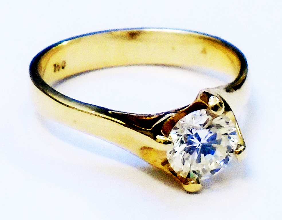 A marked 750 yellow metal 0.62ct diamond solitaire ring - with copy of the valuation certificate