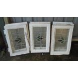 Seven matching pine framed leaded window lights with single flower motif