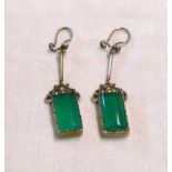 A pair of 1920's white metal drop earrings, each set with rounded oblong green hardstone panel