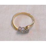 An 18ct. gold three stone diamond cross-over ring - 0.33ct. TDW