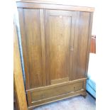 A 4' 6" early 20th Century polished oak wardrobe with central panelled door and deep drawer under,