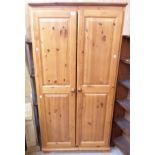 A 35" modern waxed pine double wardrobe, set on bracket feet