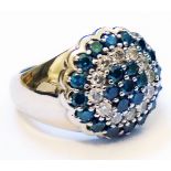 A marked 14k white metal ring, set with a blue and white diamond encrusted central panel