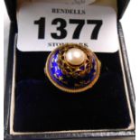 A marked .585 yellow metal dome top ring, set with central pearl within a blue enamelled border