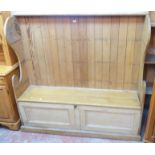 A 5' 3 1/2" antique pine and mixed wood wingback settle with locker seat and panelled front -