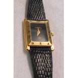A gold tone cased Gucci lady's wristwatch with black oblong dial and original black leather