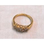 An 18ct. gold ring, set with three diamond encrusted flowerheads
