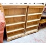 A pair of 26" stripped pine four shelf open bookcases with moulded tops and bracket bases