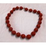 A single string cinnabar carved bead necklace with floral scroll decoration