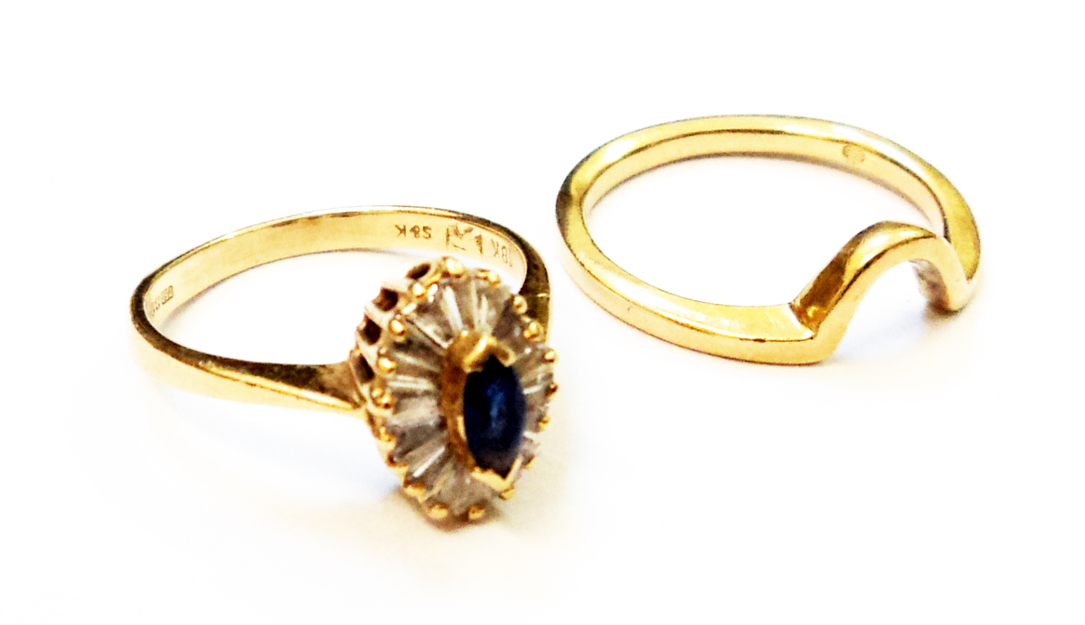 An 18ct. gold ring, set with central small marquise cornflower blue sapphire within a paved baguette