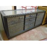 A 5' 2" painted wood and decorative woven cane panel sideboard with glass inset top, three central