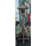 A wooden bird table with hexagonal top