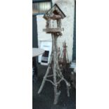 A rustic bird table, set on natural branch supports