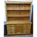 A 5' Victorian waxed pine dresser base with central panelled cupboard, six flanking graduated