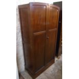A 36" 1920's mahogany wardrobe with shelf and hanging space enclosed by a pair of panelled doors,