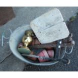 An old galvanised tin bath containing an iron boot scrape, brass table oil lamp and other items