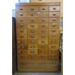 A 3' 10 1/4" mid 20th Century oak and mixed wood file chest with four flights of ten drawers over