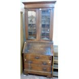 A 34" early 20th Century oak bureau bookcase with moulded cornice and three shelves enclosed by a