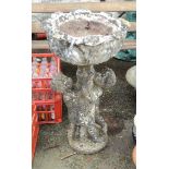 A 3' high cast concrete two part garden planter in the form of a putto holding the foliate bowl