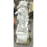 A 23" cast concrete garden statue of a putto playing a flute, sat on a 13" pedestal