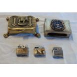 Three miniature cigarette lighters, a metal matchbox holder with armorial device and a brass trinket