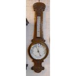 A late Victorian carved oak cased aneroid banjo barometer/thermometer with printed dial and scale