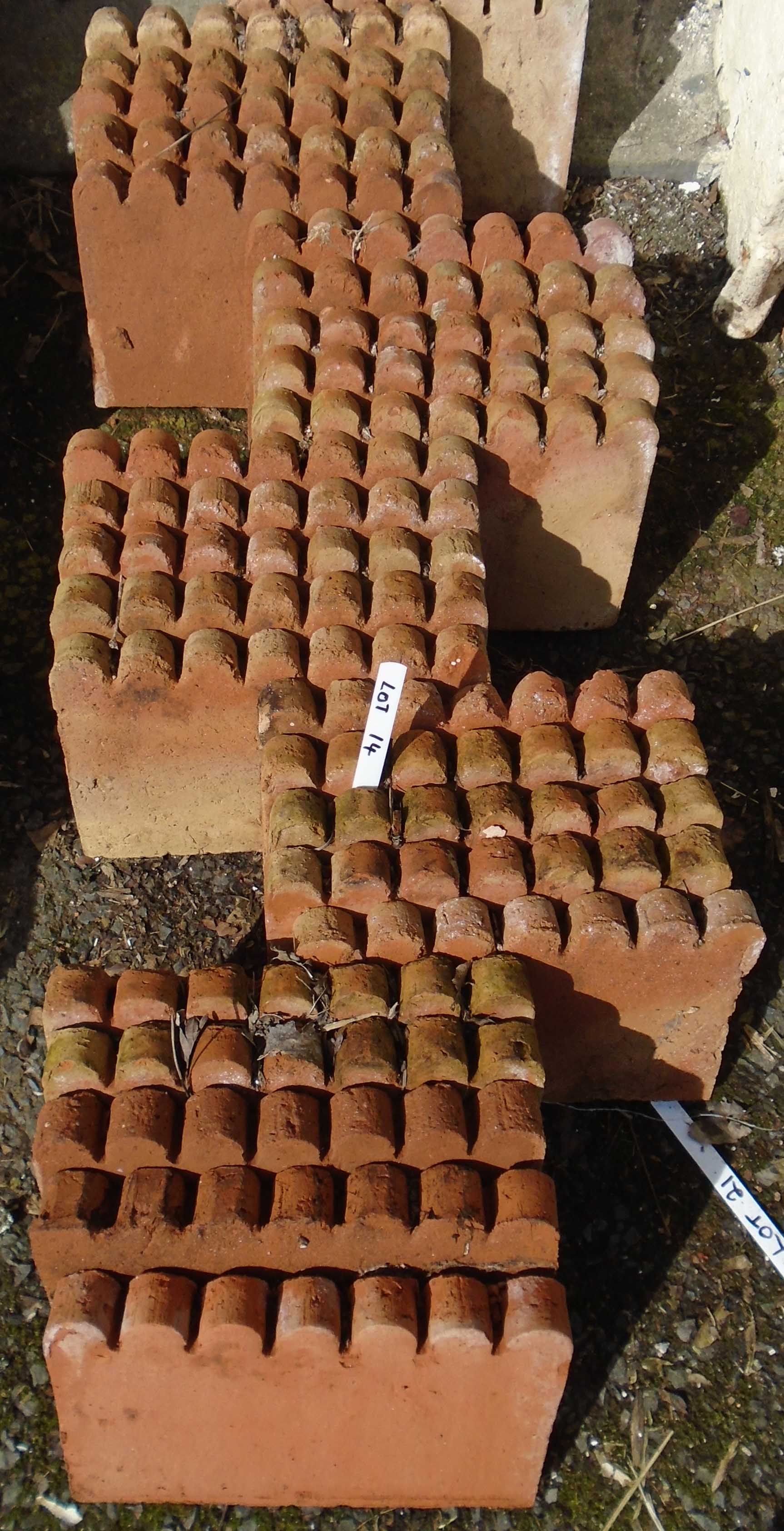 Thirty scalloped shaped terracotta edging tiles