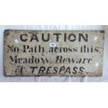 An old painted wood 'Beware of Trespass' sign