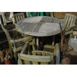 A 47" diameter slatted teak garden table and a set of four matching elbow chairs