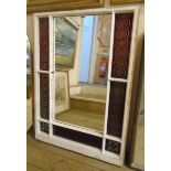 An old painted window frame with central mirror plate and coloured flashed glass border panels -