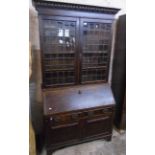 A 3' 10" early 20th Century stained oak two part bureau bookcase with leaded glazed panel doors over