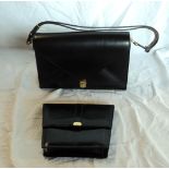 A black leather handbag and similar clutch