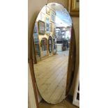 A large frameless oval mirror, formerly from a dressing table