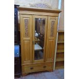 A 3' 9 1/2" Edwardian satin walnut wardrobe with carved pediment, flanking decorative fielded panels