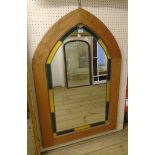 A polished wood framed stylised Gothic arch wall mirror with leaded coloured glass border