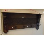 A 36 1/2" early 20th Century polished oak wall mounted coat rack with decorative central panel,