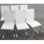 A set of six chrome framed and white leather upholstered dining chairs