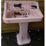 A vintage pink pedestal sink