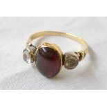 An antique yellow metal re-set cabochon garnet and foil backed paste ring