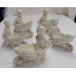 Five bonbon dishes in the form of a putto pushing a leaf wheelbarrow