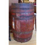 A 28" antique iron bound coopered barrel with red stained finish and remains of printed text