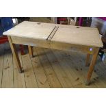 A 3' 4" vintage side-by-side school desk with twin lift-tops and inkwell apertures, set on moulded