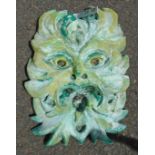 A painted concrete Green Man pattern wall mask