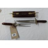 A vintage Indian made carving set in carved wood double ended sheath with brass furniture