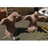 A pair of 20" high precast and painted eagles with glass eyes