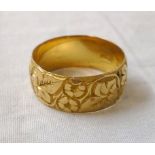 An 18ct. gold wedding band with engraved decoration - Birmingham 1912